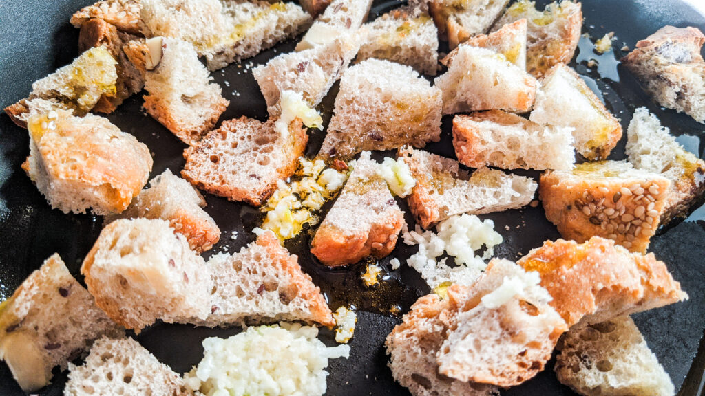 Brotwürfel mit Knoblauch als Croutons in einer Pfanne