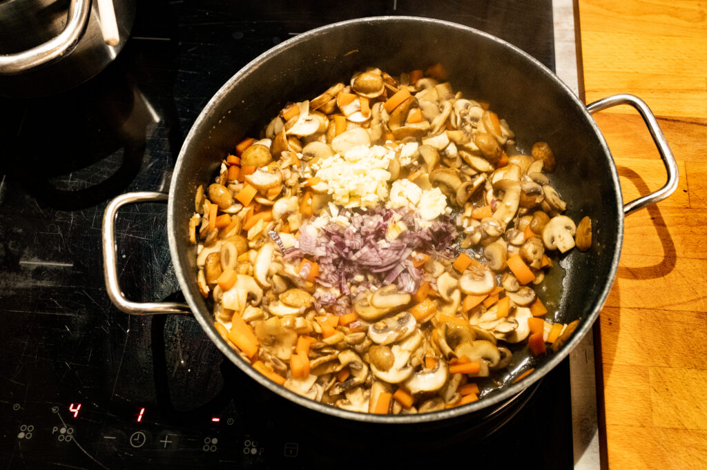 HERZHAFTE WAFFELN MIT PILZ STROGANOFF Zwiebeln und Knoblauch hinzufügen